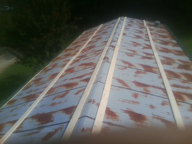 Rusted metal roof panels with new wood purlins before replacement — Storm Damage Roof Repair in Mc Coll by Roofing Brothers